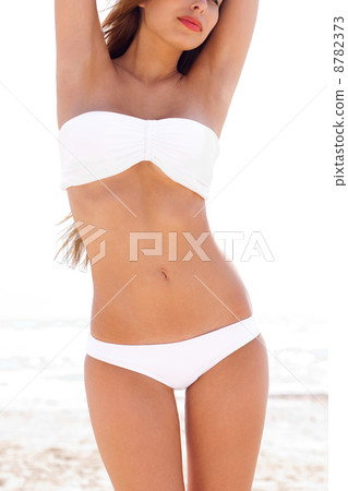 woman on the beach wearing white bikini 8782373