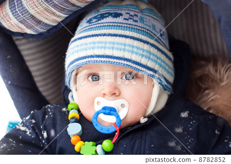 Baby boy in pram during winter snow fall 8782852