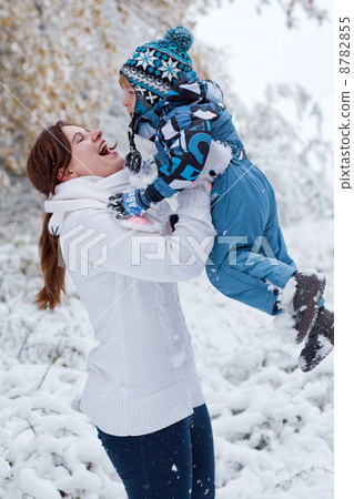 Mother and toddler boy having fun with snow on winter day 8782855