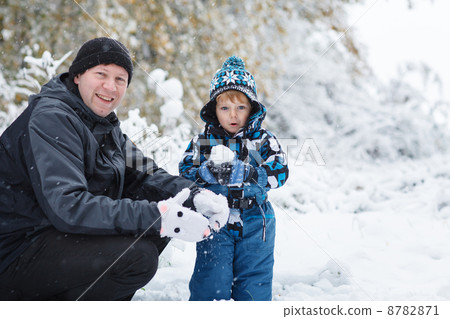 Father and toddler boy having fun with snow on winter day 8782871
