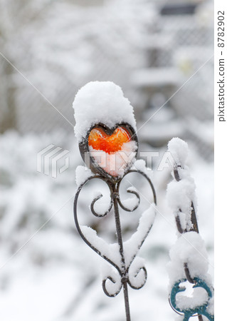 Red iron heart with snow outdoors 8782902