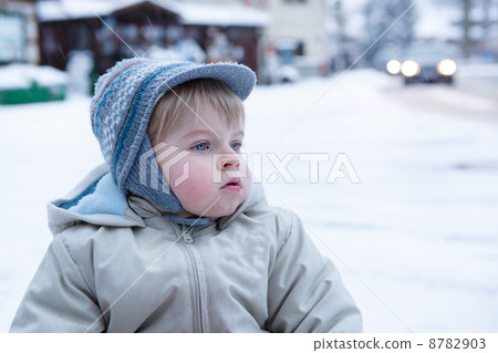 Little toddler boy having fun with snow outdoors on beautiful wi 8782903