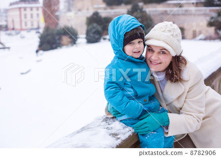 Mother and toddler boy having fun with snow on winter day 8782906