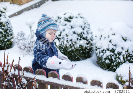 Little boy of one year having fun with snow 8782911