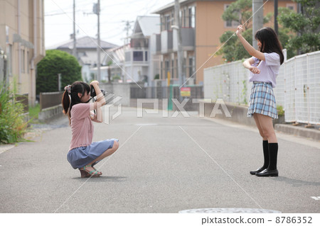 School girls posing for older sister shooting camera 8786352