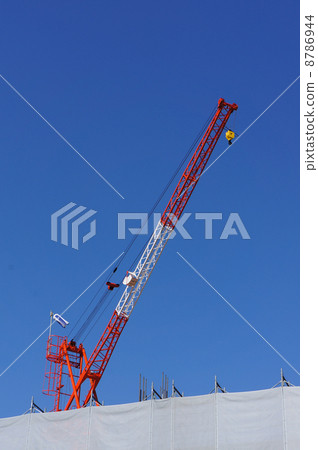 A crane extending into the blue sky 8786944