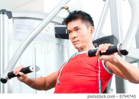 Chinese Man training strength in fitness gym 8794740