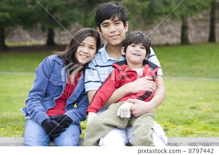 Children taking care of disabled brother at park 8797442