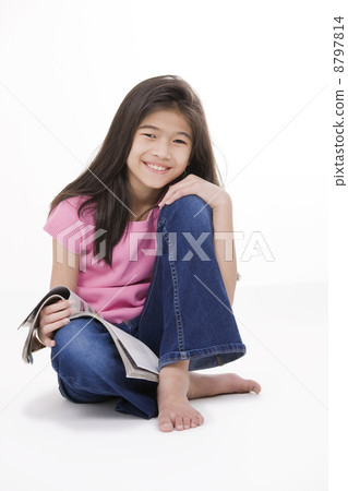 Little girl sitting on floor reading a magazine Little girl sitting on floor reading a magazine 8797814
