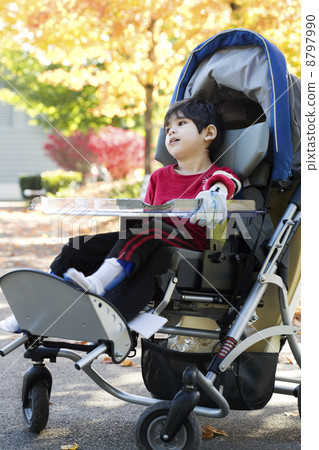 Disabled boy in medical stroller outdoors 8797990