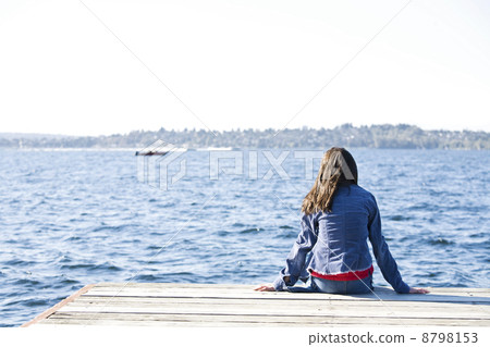 Child sitting alone on dock 8798153