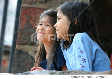 Children looking out over stone wall 8798169
