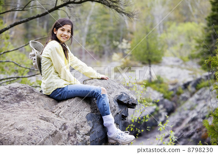 Girl sitting on rock cliff edge Girl sitting on rock cliff edge 8798230