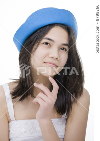 Young teenage girl in blue hat, with thoughtful expression.Isola 8798266