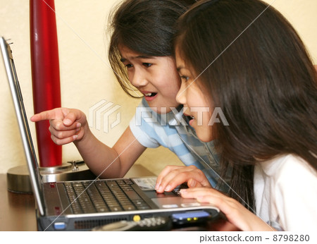 Two little girls working on a laptop Two little girls working on a laptop 8798280