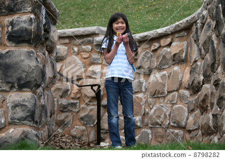 Little girl holding small flowers outdoors Little girl holding small flowers outdoors 8798282