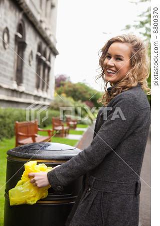 Woman putting plastic waste in garbage bin Woman putting plastic waste in garbage bin 8800370