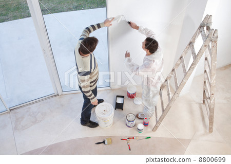 Young man showing a spot on wall Young man showing a spot on wall 8800699
