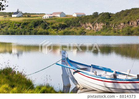 Floating Wooden Boat with Paddles in a Water Floating Wooden Boat with Paddles in a Water 8814373
