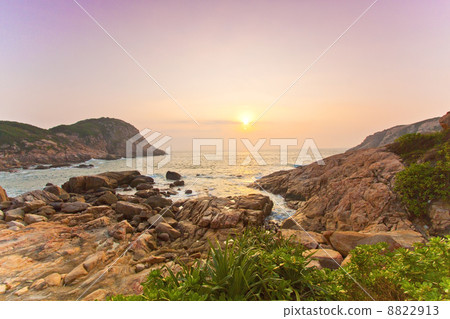 Sea rocks along the coast under sunrise 8822913