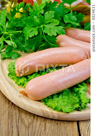 Sausages on a board with parsley and oil 8824631
