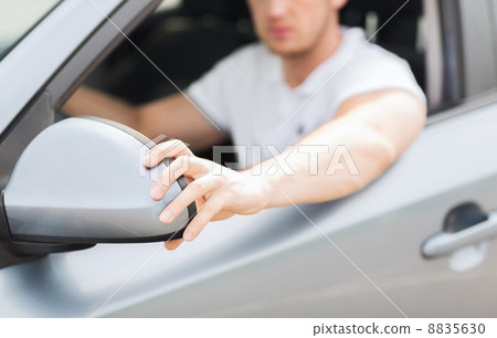 man ajusting rear view mirror 8835630