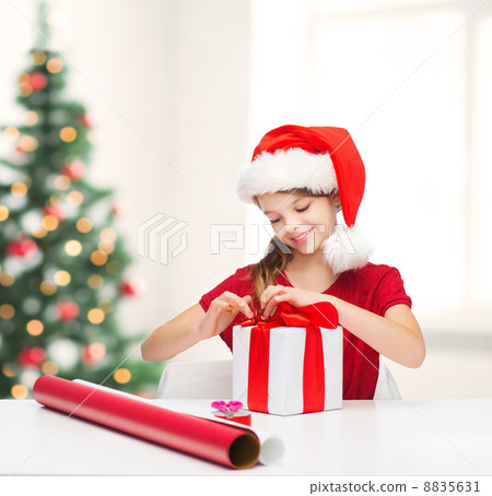 smiling girl in santa helper hat with gift box smiling girl in santa helper hat with gift box 8835631