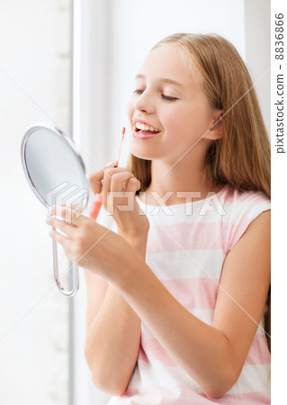 teenage girl with lip gloss and mirror 8836866
