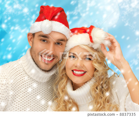 family couple in sweaters and santas hats 8837335