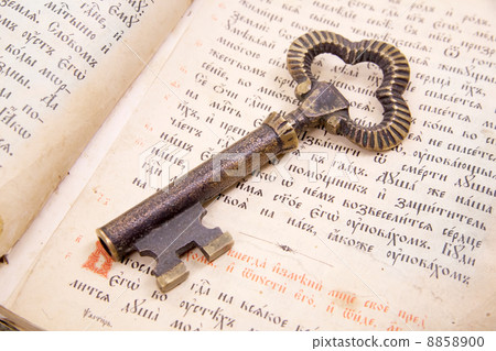 Closeup of key placed on vintage book bible Closeup of key placed on vintage book bible 8858900