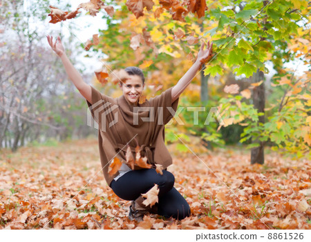 Woman throws autumn leaves 8861526