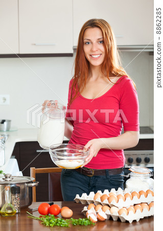 Smiling woman cooking scrambled eggs Smiling woman cooking scrambled eggs 8862285