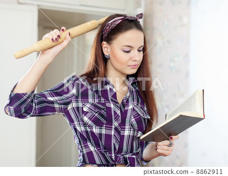 young woman reading cookbook young woman reading cookbook 8862911