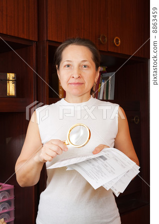 mature woman looking at utility bills mature woman looking at utility bills 8863459