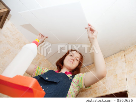 Girl glues ceiling tile Girl glues ceiling tile 8863626