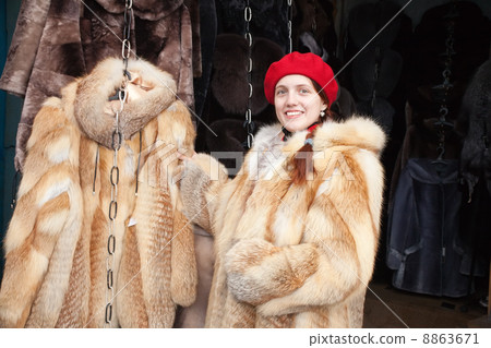 girl chooses a fur coat 8863671