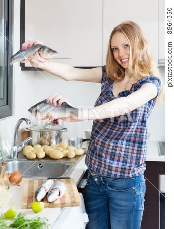 Smiling blonde woman with seabass fish Smiling blonde woman with seabass fish 8864350