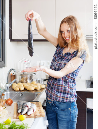 Smiling blonde woman with raw fish Smiling blonde woman with raw fish 8864431