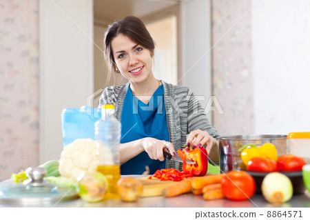 beautiful woman cuts red pepper beautiful woman cuts red pepper 8864571