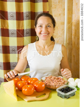 woman with ingredients for stuffed tomato 8864632