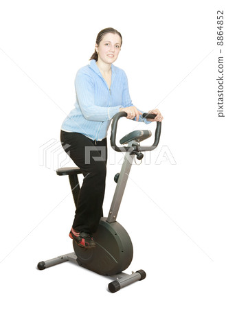 Girl workout on stationary bicycle Girl workout on stationary bicycle 8864852