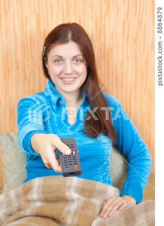 woman smiling with TV remote control woman smiling with TV remote control 8864879