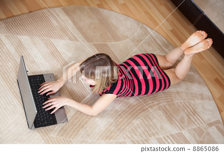 girl lying on floor and using laptop 8865086