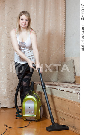 Woman cleans with vacuum cleaner Woman cleans with vacuum cleaner 8865557