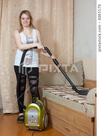 Woman cleans with vacuum cleaner Woman cleans with vacuum cleaner 8865579