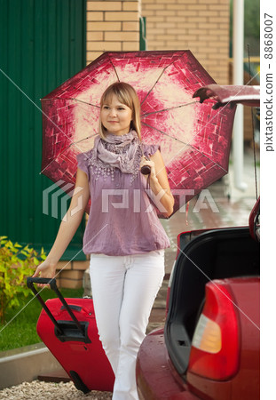 woman with luggage walking to car woman with luggage walking to car 8868007