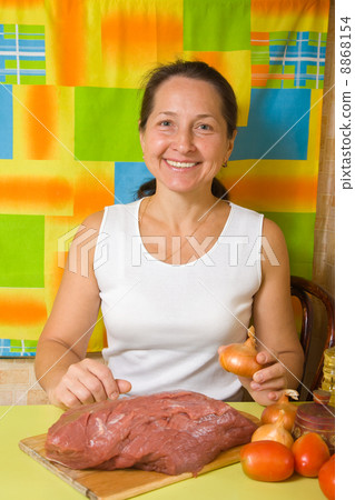 Mature woman with beef in her kitchen Mature woman with beef in her kitchen 8868154