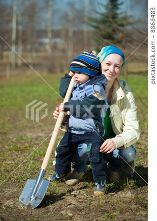 woman and boy with spade in garden 8868483