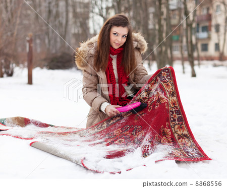 woman cleans rug with snow 8868556