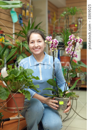 Happy mature woman with Phalaenopsis 8869025